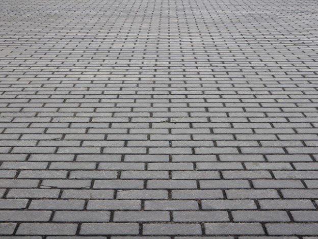 Gray brick paver driveway installed in a running bond pattern for residential property in North Ridgeville, OH