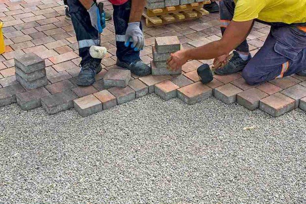 Concrete contractors installing paver driveway edge with gravel base preparation in North Ridgeville, OH