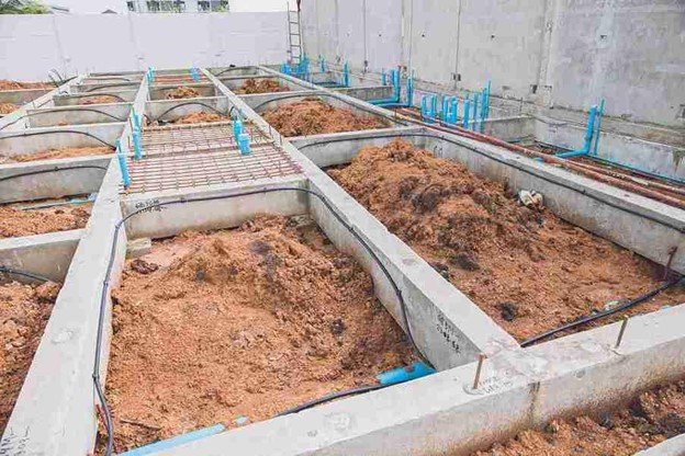 Concrete foundation installation with footing layout and plumbing lines prepared for residential build in North Ridgeville, OH
