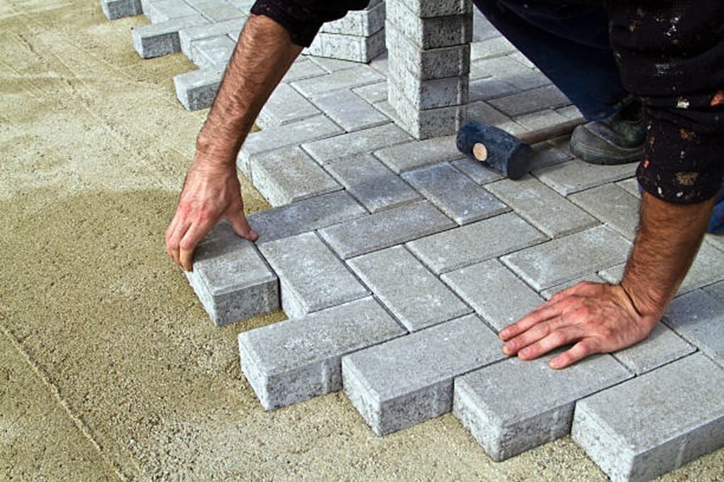 Contractor installing concrete pavers for patio construction on compacted base in North Ridgeville, OH
