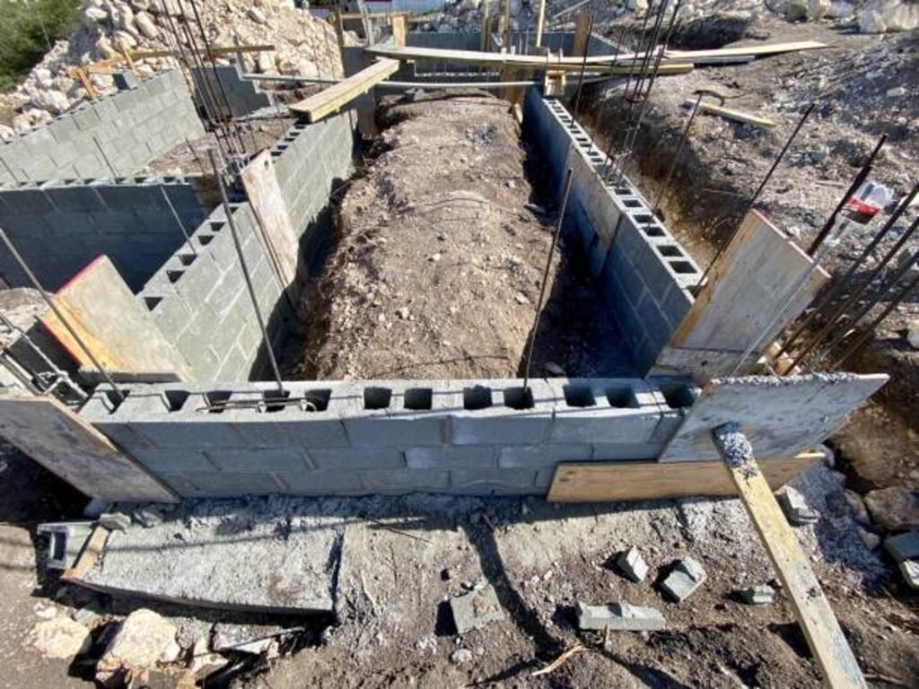Concrete foundation installation with block walls and framing setup on construction site in North Ridgeville, OH