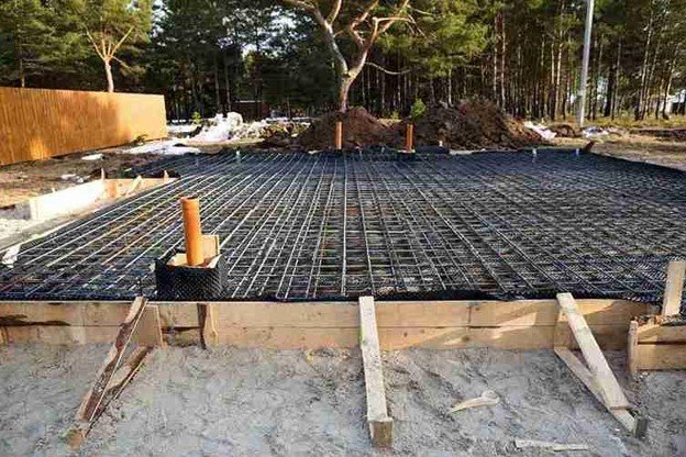 Concrete slab preparation with steel rebar reinforcement grid before pouring foundation in North Ridgeville, OH