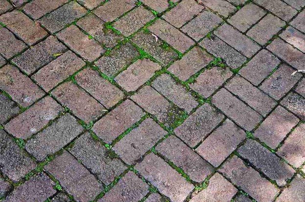 Uneven patio surface with shifting pavers and gaps before concrete patio replacement in North Ridgeville, OH